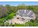 Aerial view of backyard of large home with manicured landscaping, covered patios, and mature trees at 10707 Club Chase, Fishers, IN 46037