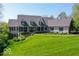 Stately home with manicured lawn, black shutters and columns, and mature trees under a clear sky at 10707 Club Chase, Fishers, IN 46037