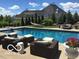 A backyard oasis featuring a large pool with comfortable lounge seating and well manicured landscaping at 10707 Club Chase, Fishers, IN 46037