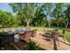 Outdoor backyard deck with a table, wicker seating and lush greenery for the ultimate relaxation experience at 11802 Prairie Pl, Carmel, IN 46033