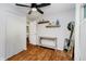 Bright bedroom with a ceiling fan, a large window, hardwood floors and decorative shelves with a full mirror at 11802 Prairie Pl, Carmel, IN 46033