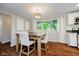 Dining area features a modern table and chairs with views of the backyard greenery at 11802 Prairie Pl, Carmel, IN 46033