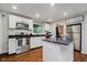 Bright kitchen featuring white cabinets, a stainless steel fridge, and an island at 11802 Prairie Pl, Carmel, IN 46033