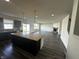 Open-concept kitchen featuring a large island, dark cabinets, stainless steel appliances and hardwood floors at 1218 Bedford Dr, Avon, IN 46123