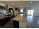 Modern kitchen boasts dark cabinetry, stainless steel appliances, granite counters, and a center island at 1218 Bedford Dr, Avon, IN 46123