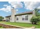 View of home's backyard with large retaining wall, chimney, and a screened-in porch at 12207 Blue Sky Dr, Fishers, IN 46037