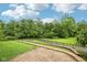 A peaceful backyard featuring a grassy area, a brick patio, and an iron fence bordering a wooded area at 12207 Blue Sky Dr, Fishers, IN 46037