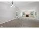 Large living room with neutral walls and carpet, a fireplace, and access to the patio through sliding doors at 12207 Blue Sky Dr, Fishers, IN 46037