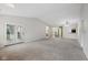 Expansive living room features neutral carpet, a vaulted ceiling, and sliding doors opening to the outdoors at 12207 Blue Sky Dr, Fishers, IN 46037