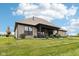 Spacious backyard with brick home, covered patio, lush lawn, and neatly manicured landscaping at 1295 Maclaren Ct, Franklin, IN 46131