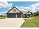 Beautiful single-story home featuring a brick facade, three-car garage, and well-manicured lawn on a sunny day at 1295 Maclaren Ct, Franklin, IN 46131