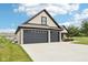 Three-car garage showcasing the home's exterior, concrete driveway, and professional landscaping at 1295 Maclaren Ct, Franklin, IN 46131