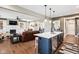 Open-concept living area with fireplace, hardwood floors, and island seating near kitchen at 1295 Maclaren Ct, Franklin, IN 46131
