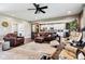 Open-concept living room with leather furniture, hardwood floors, and view into the kitchen area at 1295 Maclaren Ct, Franklin, IN 46131