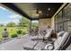 Inviting covered patio with lounge chairs, ceiling fan, and brick facade overlooking the golf course at 1295 Maclaren Ct, Franklin, IN 46131