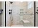 Bright shower with frameless glass, rainfall shower head, built-in seat and shelving, and mosaic tile accents at 1295 Maclaren Ct, Franklin, IN 46131