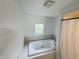 The bathroom features a large soaking tub with jets, tile accents and a window with a view of the landscape at 1445 S 750 W, Shelbyville, IN 46176