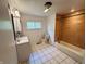 Full bathroom featuring neutral tile flooring, a built-in tub and shower, and a vanity with a decorative mirror at 1445 S 750 W, Shelbyville, IN 46176