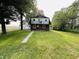 Two-story home with a brick and white exterior, front balcony, and a spacious lawn at 1445 S 750 W, Shelbyville, IN 46176