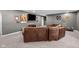 Comfortable finished basement lounge area with a large leather couch and mounted television at 15047 Glenmoor Cir, Carmel, IN 46033