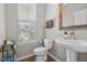 Modern bathroom featuring a pedestal sink, stylish fixtures, and window for natural light at 15047 Glenmoor Cir, Carmel, IN 46033