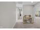 Bright hallway featuring neutral walls and carpet, with a decorative table showcasing Gathering photos at 15047 Glenmoor Cir, Carmel, IN 46033