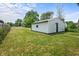 Backyard featuring a detached single car garage with white vinyl siding and a well maintained lawn at 1529 E Tabor St, Indianapolis, IN 46203