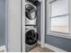 A laundry area featuring a stacked washer and dryer set and a window at 1529 E Tabor St, Indianapolis, IN 46203