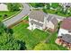 Aerial shot of a backyard with a concrete patio, surrounded by lush green grass, vinyl siding, and a wood fence at 16138 Palmyra Green, Westfield, IN 46074