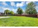 Expansive backyard with lush green lawn, bordered by a wooden fence and mature trees, offering privacy and space at 16138 Palmyra Green, Westfield, IN 46074