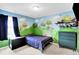 This charming bedroom features a custom-painted wall mural and a cool navy blue bedspread at 16138 Palmyra Green, Westfield, IN 46074