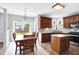 Open kitchen and dining area featuring wood cabinets, granite counters, and stainless steel appliances at 16138 Palmyra Green, Westfield, IN 46074