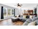 Inviting living room with a large sofa, hardwood floors, and bright natural light from the windows at 16138 Palmyra Green, Westfield, IN 46074