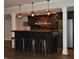Finished basement bar featuring pendant lighting, seating and wooden bar at 16550 Gleneagles Ct, Noblesville, IN 46060