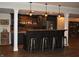 Finished basement bar with dark wood accents, pendant lighting, and seating at 16550 Gleneagles Ct, Noblesville, IN 46060