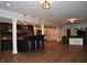 Open basement layout with a bar, stools, and adjacent living area for entertaining at 16550 Gleneagles Ct, Noblesville, IN 46060