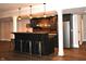 Finished basement with a custom bar, dark wood cabinets, and stainless steel refrigerator at 16550 Gleneagles Ct, Noblesville, IN 46060