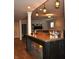 Finished basement bar area with unique pendant lighting, wooden bar, and open floor at 16550 Gleneagles Ct, Noblesville, IN 46060