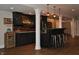 Finished basement bar with dark wood accents, pendant lighting, and seating for entertaining at 16550 Gleneagles Ct, Noblesville, IN 46060