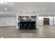 Basement bar area with seating, custom cabinets, wood paneling, and modern pendant lighting at 16550 Gleneagles Ct, Noblesville, IN 46060