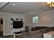 Finished basement living room with gray sectional and built-in shelving for entertainment at 16550 Gleneagles Ct, Noblesville, IN 46060