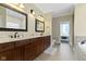 Well-lit bathroom featuring double vanity sinks, marble countertops, and a separate tub and toilet area at 16550 Gleneagles Ct, Noblesville, IN 46060