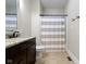 Bathroom showcases dark cabinets, granite counters, and a shower with a striped curtain, hooks on wall at 16550 Gleneagles Ct, Noblesville, IN 46060