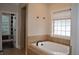 Bathroom featuring a tub with tile surround, and window with blind at 16550 Gleneagles Ct, Noblesville, IN 46060