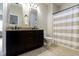 Bathroom boasts dual mirrors over granite counters, dark cabinets, and a tub with a striped shower curtain at 16550 Gleneagles Ct, Noblesville, IN 46060