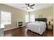 A cozy bedroom featuring a ceiling fan, two windows, and a comfortable bed with wood-look flooring at 16550 Gleneagles Ct, Noblesville, IN 46060