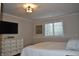 Bright bedroom with a white dresser, mounted TV, and sunlit window at 16550 Gleneagles Ct, Noblesville, IN 46060