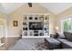 Living room boasting a built-in bookcase, gray sofa, and vaulted ceiling at 16550 Gleneagles Ct, Noblesville, IN 46060
