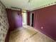 Bedroom with unfinished floors, purple paint, and a floral wallpaper border at 1739 E 18Th St, Anderson, IN 46016