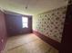 Bedroom with unfinished floors, red paint, and a floral wallpaper border at 1739 E 18Th St, Anderson, IN 46016